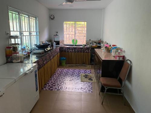 eine Küche mit einem Tisch und einem Stuhl darin in der Unterkunft Homestay Sweetcorn in Kampong Alor Gajah