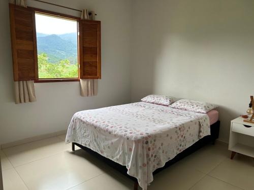 Dormitorio blanco con cama y ventana en Agradável Casa de Campo, recém construída., en Divisa