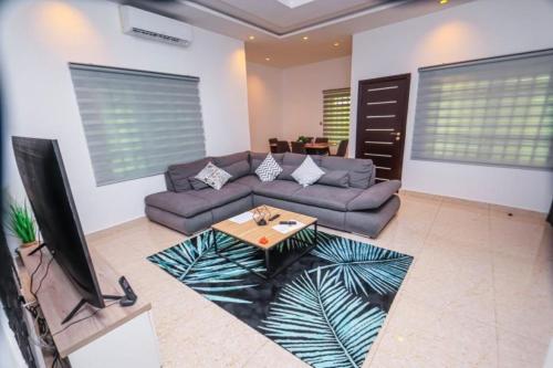 a living room with a couch and a table at RESIDENCE MH SERVICES Cotonou in Cotonou