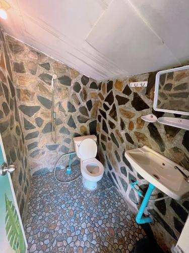 a stone bathroom with a toilet and a sink at Silver cliff room 3 in Than Sadet Beach