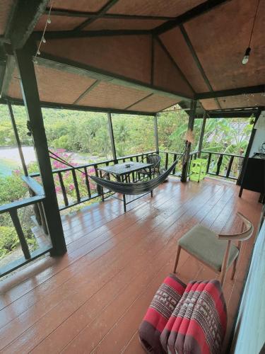 a room with a wooden floor with tables and chairs at Silver cliff room 3 in Than Sadet Beach