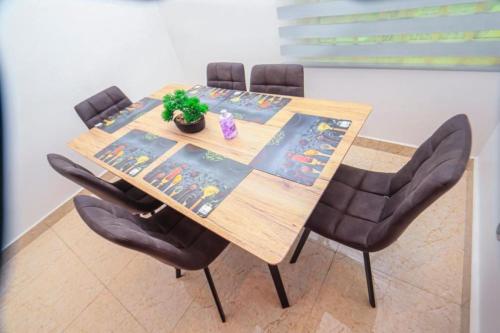 a dining room table with four chairs and a plant on it at RESIDENCE MH SERVICES Cotonou in Cotonou
