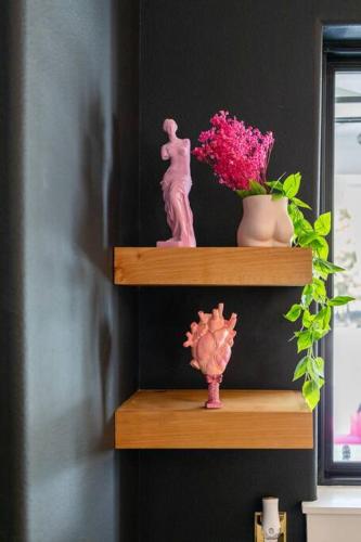 a shelf with a statue of a woman and flowers at Tiger Mansion-Paradise with Pool in Waxahachie