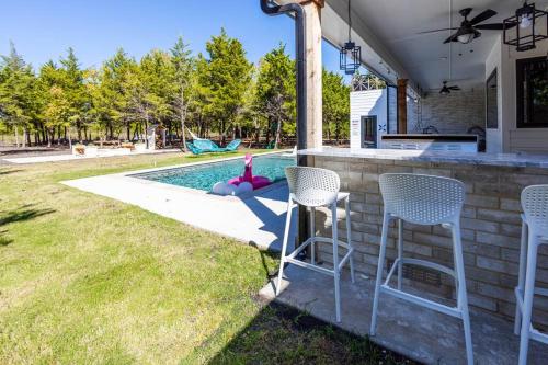 a backyard with chairs and a swimming pool at Tiger Mansion-Paradise with Pool in Waxahachie