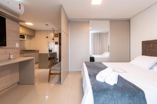 une chambre d'hôtel avec un lit et une cuisine dans l'établissement Charmosos Flats no Setor Bueno TXP, à Goiânia