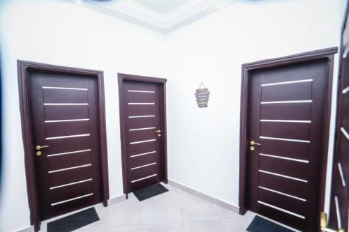 two doors in a room with white walls at RESIDENCE MH SERVICES Cotonou in Cotonou