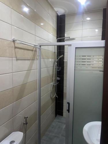 a bathroom with a shower and a toilet and a sink at RESIDENCE MH SERVICES Cotonou in Cotonou