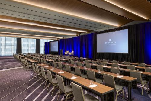 a conference room with tables and chairs and a screen at JW Marriott Dallas Arts District in Dallas