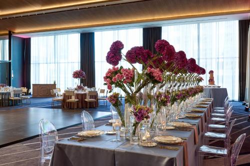 a long table with vases of purple flowers on it at JW Marriott Dallas Arts District in Dallas