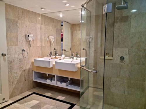 uma casa de banho com 2 lavatórios e um chuveiro em The Jerai Hotel Alor Star em Alor Setar