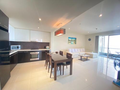 a kitchen and living room with a table and a couch at The Sea Luxury Nha Trang Apartment in Nha Trang