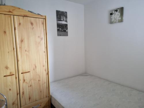a bedroom with a bed and a wooden cabinet at Appartement T2 - 3 pers - à 400m de la plage, centre station, avec loggia - Biscarrosse Plage - FR-1-521-120 in Biscarrosse-Plage