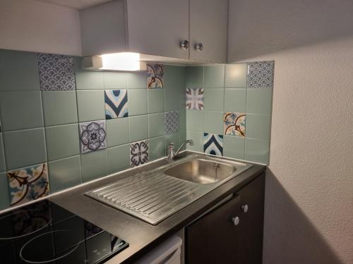 a kitchen with a sink and tiles on the wall at Appartement T2 - 3 pers - à 400m de la plage, centre station, avec loggia - Biscarrosse Plage - FR-1-521-120 in Biscarrosse-Plage