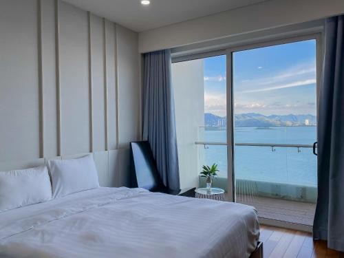 a hotel room with a bed and a large window at The Sea Luxury Nha Trang Apartment in Nha Trang