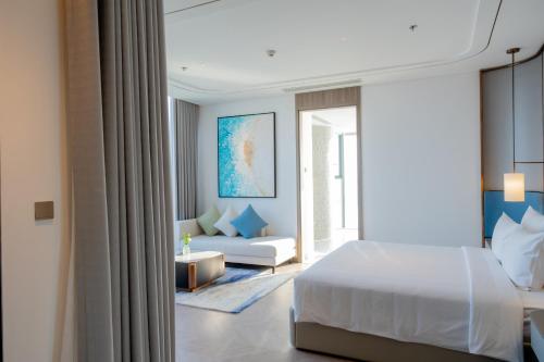 a bedroom with a bed and a living room at A La Carte Ha Long Bay Managed by TASECO in Ha Long