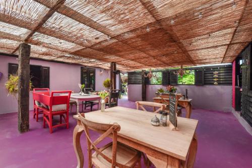 a patio with tables and chairs and a wooden ceiling at Mammaloe in Oranjestad