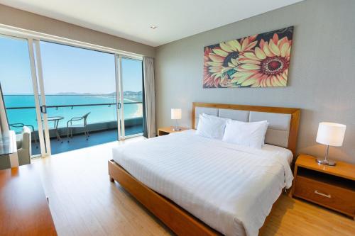 a bedroom with a large bed with a view of the ocean at The Sea Luxury Nha Trang Apartment in Nha Trang