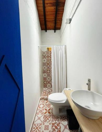 a bathroom with a white toilet and a sink at EL PAILON FINCA in Quebradaseca