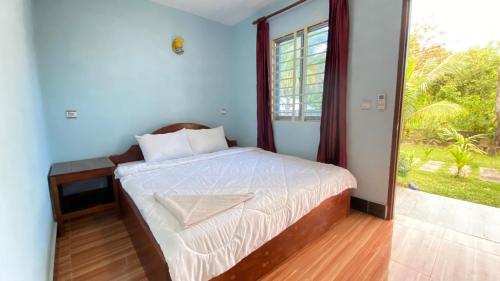 a bedroom with a bed and a large window at Koh Rong 71 Guesthouse in Koh Rong Island
