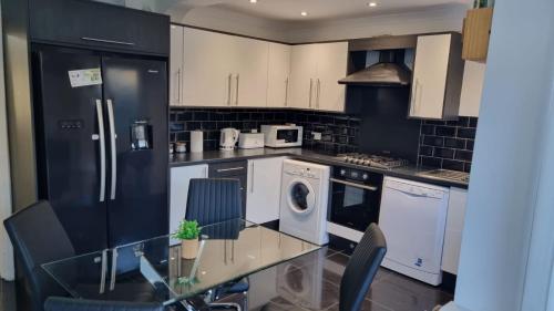 a kitchen with white appliances and a glass table at B43 Cosy Home - Contractor-Family Stays Near Bhm City-Off Road Parking Free Wi-fi in Holly Lane