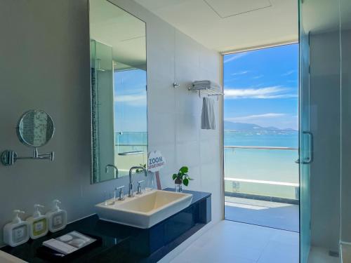 een badkamer met een wastafel en uitzicht op de oceaan bij The Sea Luxury Nha Trang Apartment in Nha Trang