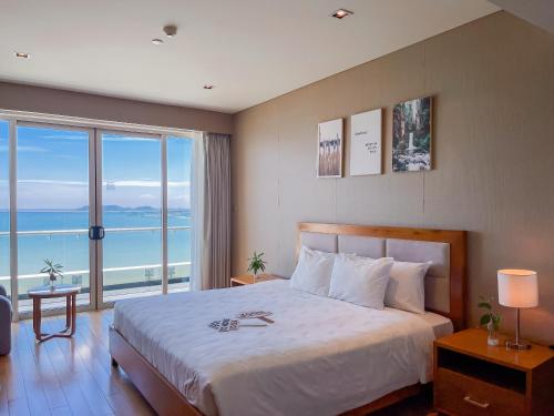 a bedroom with a bed with a view of the ocean at The Sea Luxury Nha Trang Apartment in Nha Trang