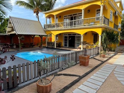 a yellow house with a swimming pool in front of it at Lukshvilla private villa Le morne wind n kite surfers accomodation & car rental mauritius in La Gaulette