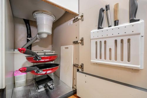 a kitchen with two red pans on a sink at 団体歓迎ジョイサウンドカラオケ付き北軽井沢超大型貸別荘7寝室5浴室20人泊まれる in Karuizawa