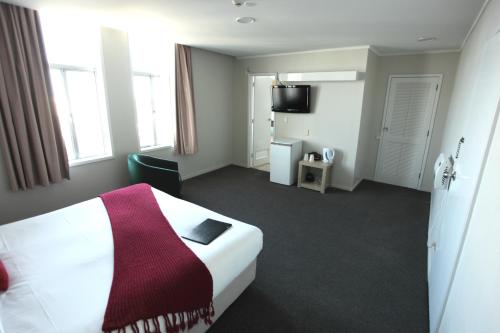 a hotel room with a bed and a television at The Grosvenor Hotel in Timaru