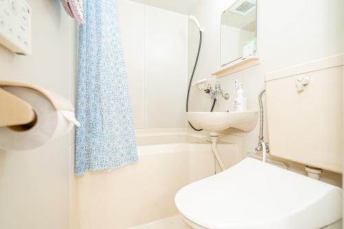a bathroom with a toilet and a sink at 団体歓迎ジョイサウンドカラオケ付き北軽井沢超大型貸別荘7寝室5浴室20人泊まれる in Karuizawa