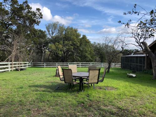 a table and chairs in a field with a fence at Fishers Of Men Ranch Home in Marble Falls
