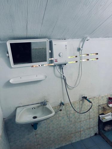 łazienka z umywalką i telewizorem na ścianie w obiekcie Silver cliff room 1 w mieście Than Sadet Beach