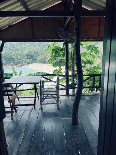 una veranda in legno con tavolo e panca di Silver cliff room 1 a Than Sadet Beach