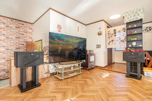 a living room with a large flat screen tv at 団体歓迎ジョイサウンドカラオケ付き北軽井沢超大型貸別荘7寝室5浴室20人泊まれる in Karuizawa