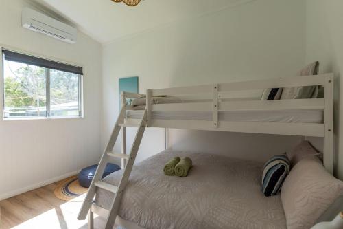 a bedroom with two bunk beds and a ladder at Golden Sands Pet Friendly 2 Mins Walk to Beach in Culburra Beach