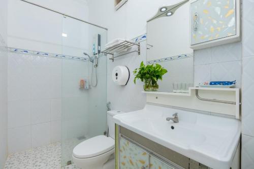 a white bathroom with a toilet and a sink at 1/9 Hồ Quý Ly, bãi sau in Vung Tau