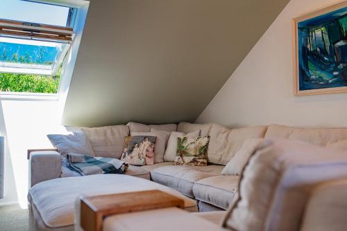 a living room with a couch and a window at Bali Escape, tropical gardens, close to 3 beaches! in Bowentown