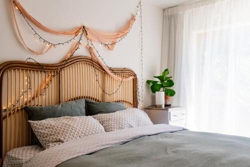 a bed with a wooden headboard in a bedroom at Bali Escape, tropical gardens, close to 3 beaches! in Bowentown
