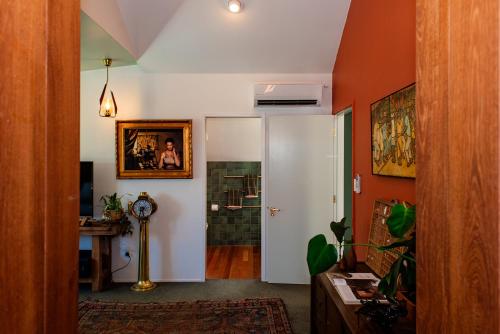 a living room with a hallway with a door and a room with a shower at Bali Escape, tropical gardens, close to 3 beaches! in Bowentown