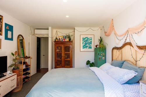 a bedroom with a large bed and a television at Bali Escape, tropical gardens, close to 3 beaches! in Bowentown