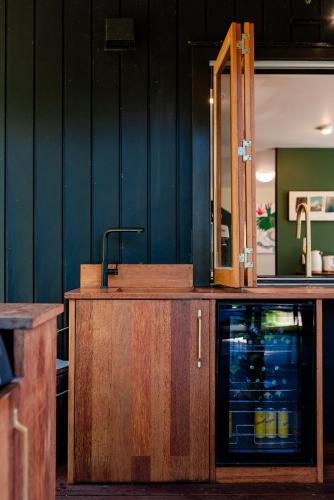 a wooden counter with a mirror and a sink at Bali Escape, tropical gardens, close to 3 beaches! in Bowentown