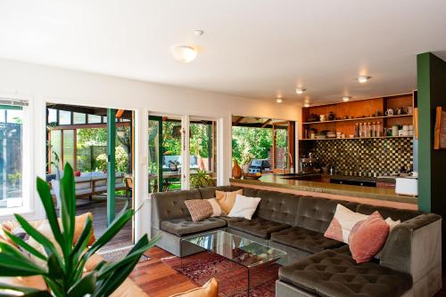 a living room with a couch and a table at Bali Escape, tropical gardens, close to 3 beaches! in Bowentown