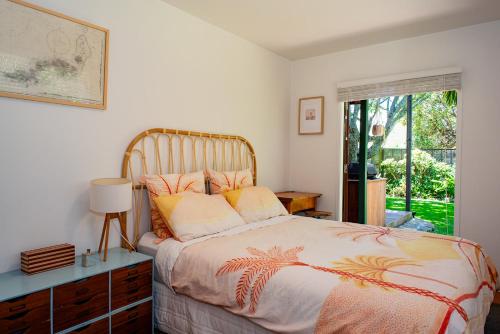 a bedroom with a bed and a window at Bali Escape, tropical gardens, close to 3 beaches! in Bowentown