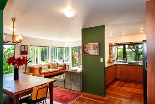 a kitchen and living room with a green wall at Bali Escape, tropical gardens, close to 3 beaches! in Bowentown