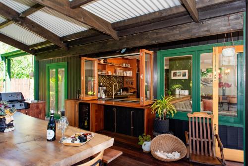a dining room with a table and a kitchen at Bali Escape, tropical gardens, close to 3 beaches! in Bowentown