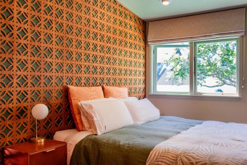 a bedroom with a bed and a window at Bali Escape, tropical gardens, close to 3 beaches! in Bowentown