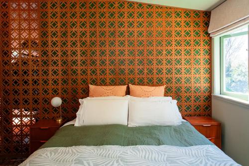 a bedroom with a bed and a colorful wall at Bali Escape, tropical gardens, close to 3 beaches! in Bowentown