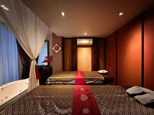 a hotel room with two beds and a bath tub at Chala Number6 in Chiang Mai