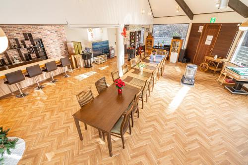 a large room with a table and chairs at 団体歓迎ジョイサウンドカラオケ付き北軽井沢超大型貸別荘7寝室5浴室20人泊まれる in Karuizawa