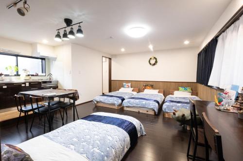 a room with four beds and a table and a kitchen at 恐竜博物館まで車で5分 自然体験 古来農業体験ができる一棟貸し宿Dinosaur Agri in Katsuyama